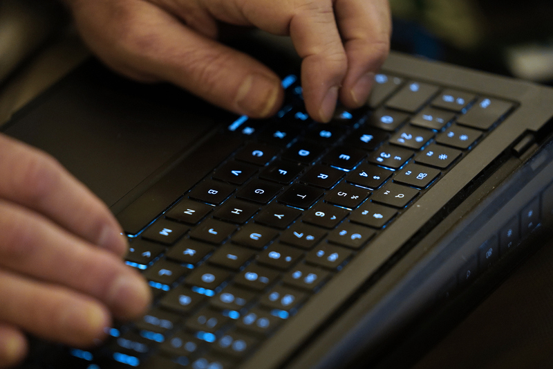 Man types on a glowing keyboard